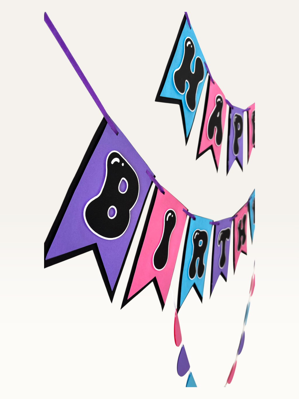 Paper Party Studio Happy Birthday bubble letter banner on swallowtail flags, in blue & gold or pink, purple & blue.