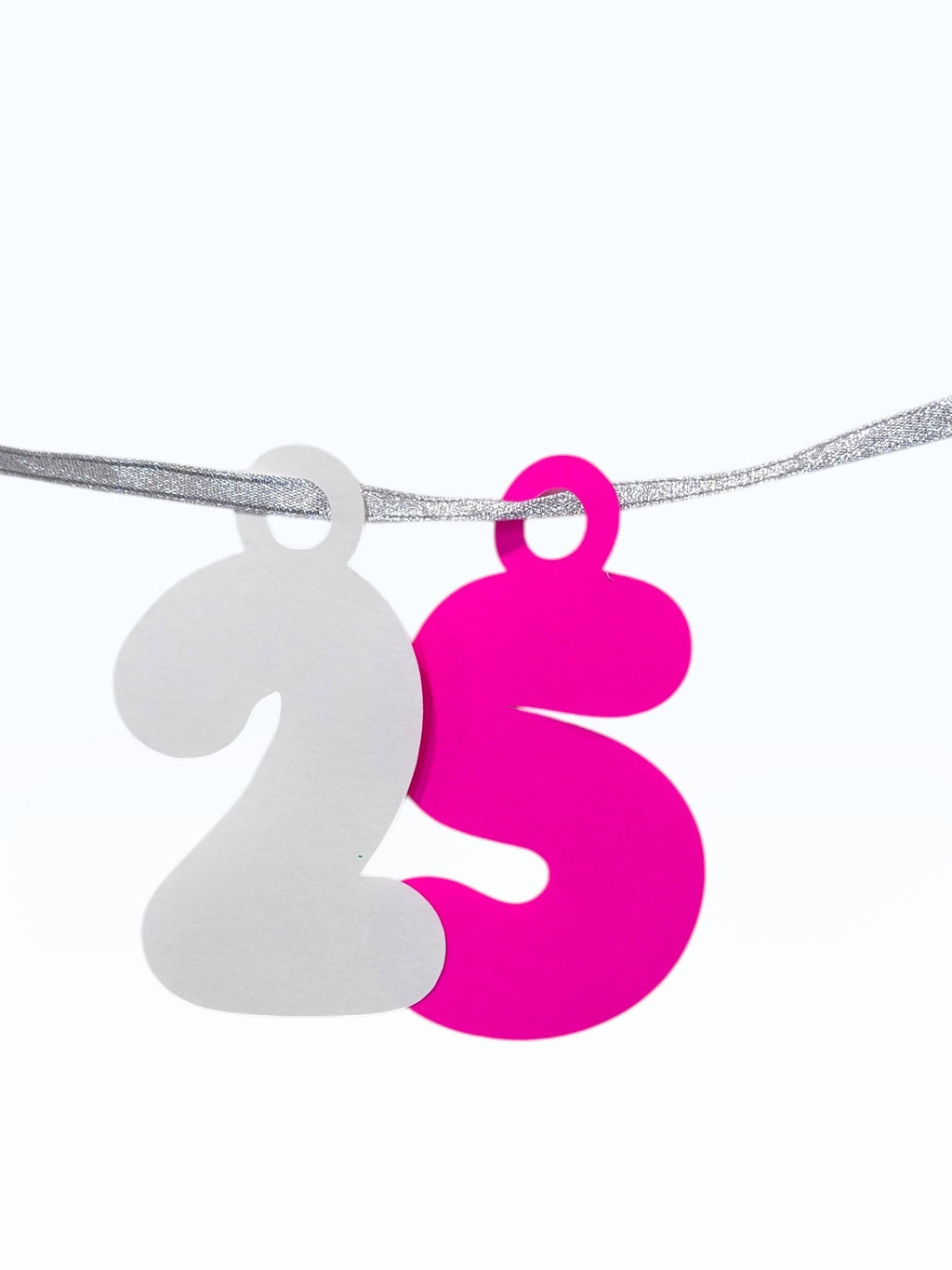 Paper Party Studio 25th birthday garland with white and pink bubble numbers on a silver cord.