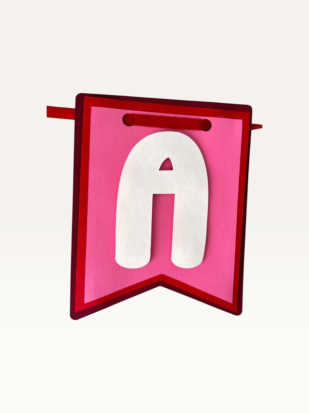 Paper Party Studio pink and red swallowtail cardstock banner flag with a white letter A for anniversary decor.