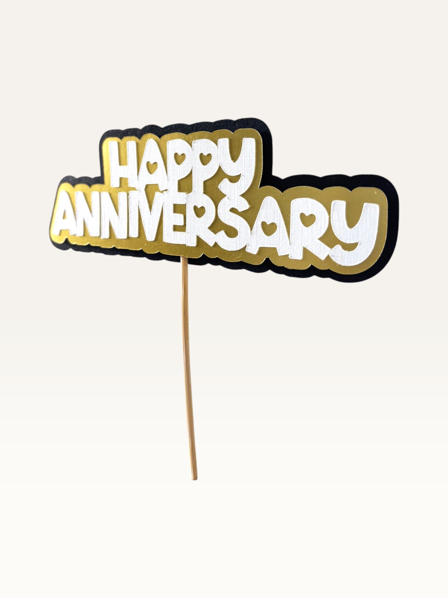 Paper Party Studio Happy Anniversary cake topper with layered white, gold, and black cardstock and heart cut-outs.