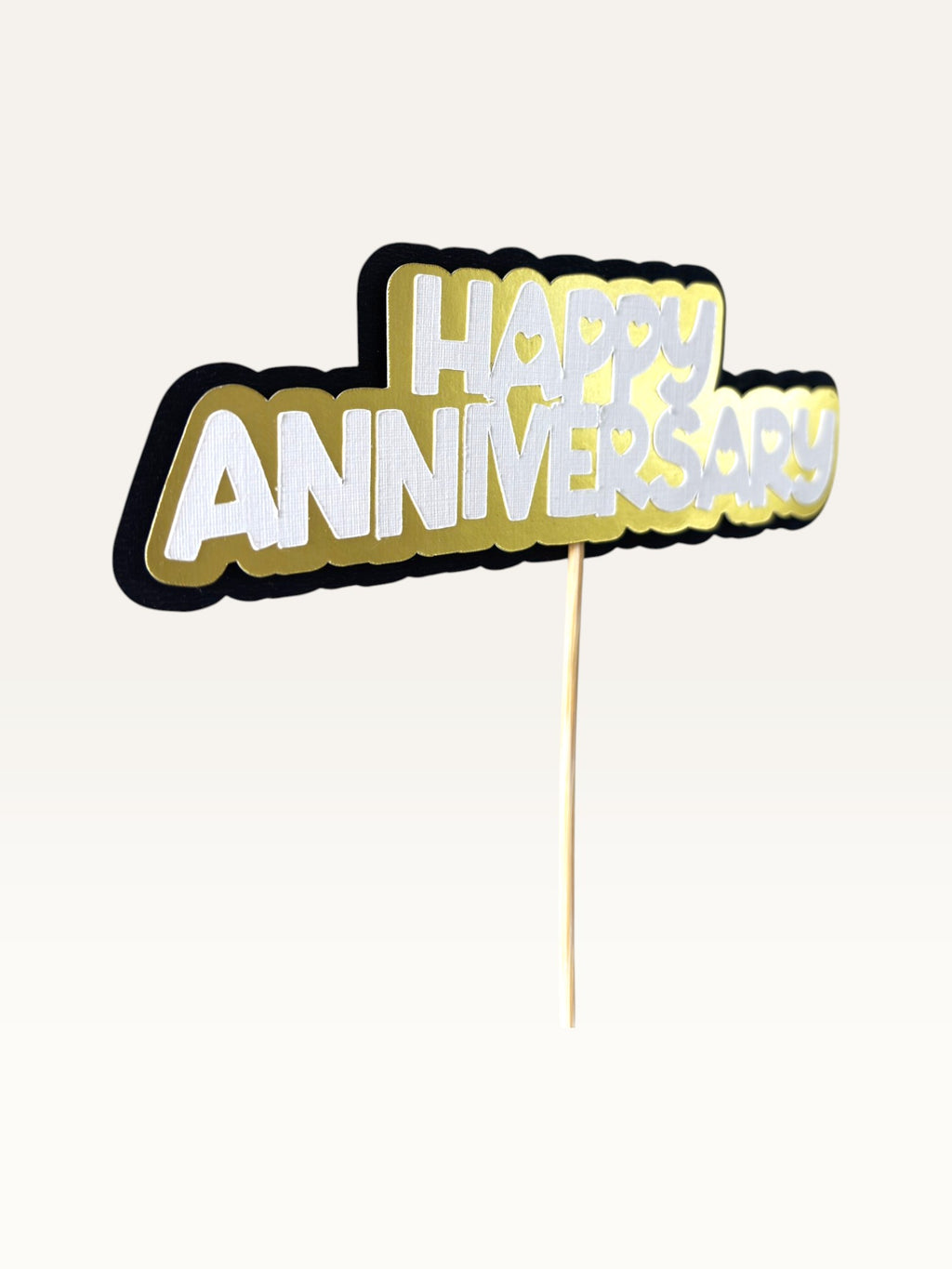 Paper Party Studio Happy Anniversary cake topper with layered white, gold, and black cardstock and heart cut-outs.