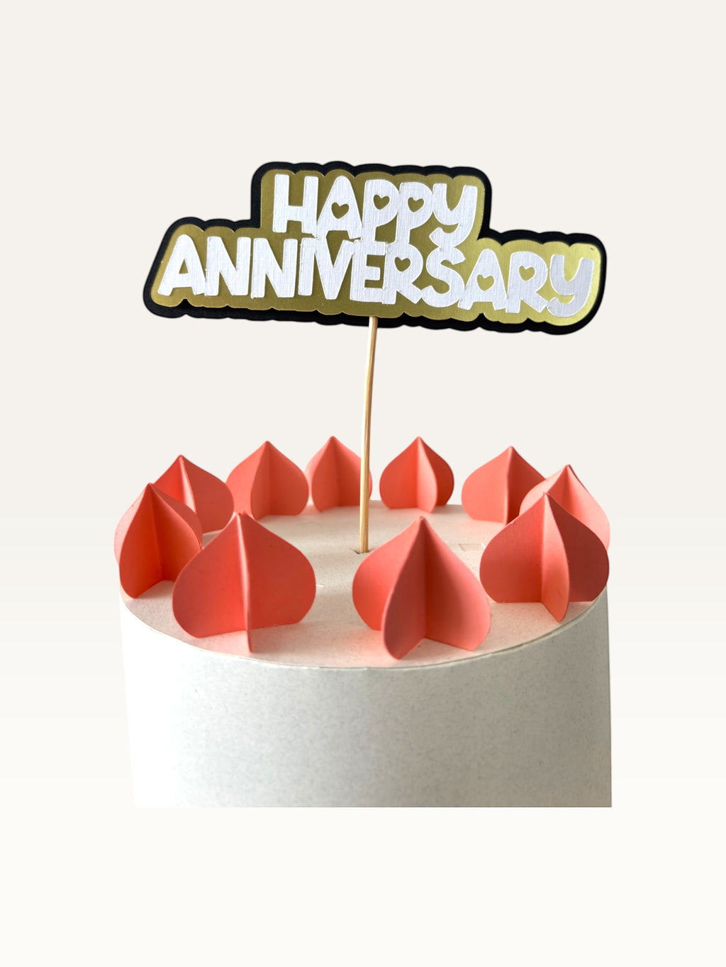 Paper Party Studio Happy Anniversary cake topper with white, gold, and black layered cardstock and heart cut-outs.