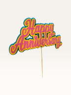 Paper Party Studio layered cardstock Happy Anniversary cake topper in pink, yellow, and teal with heart detail.