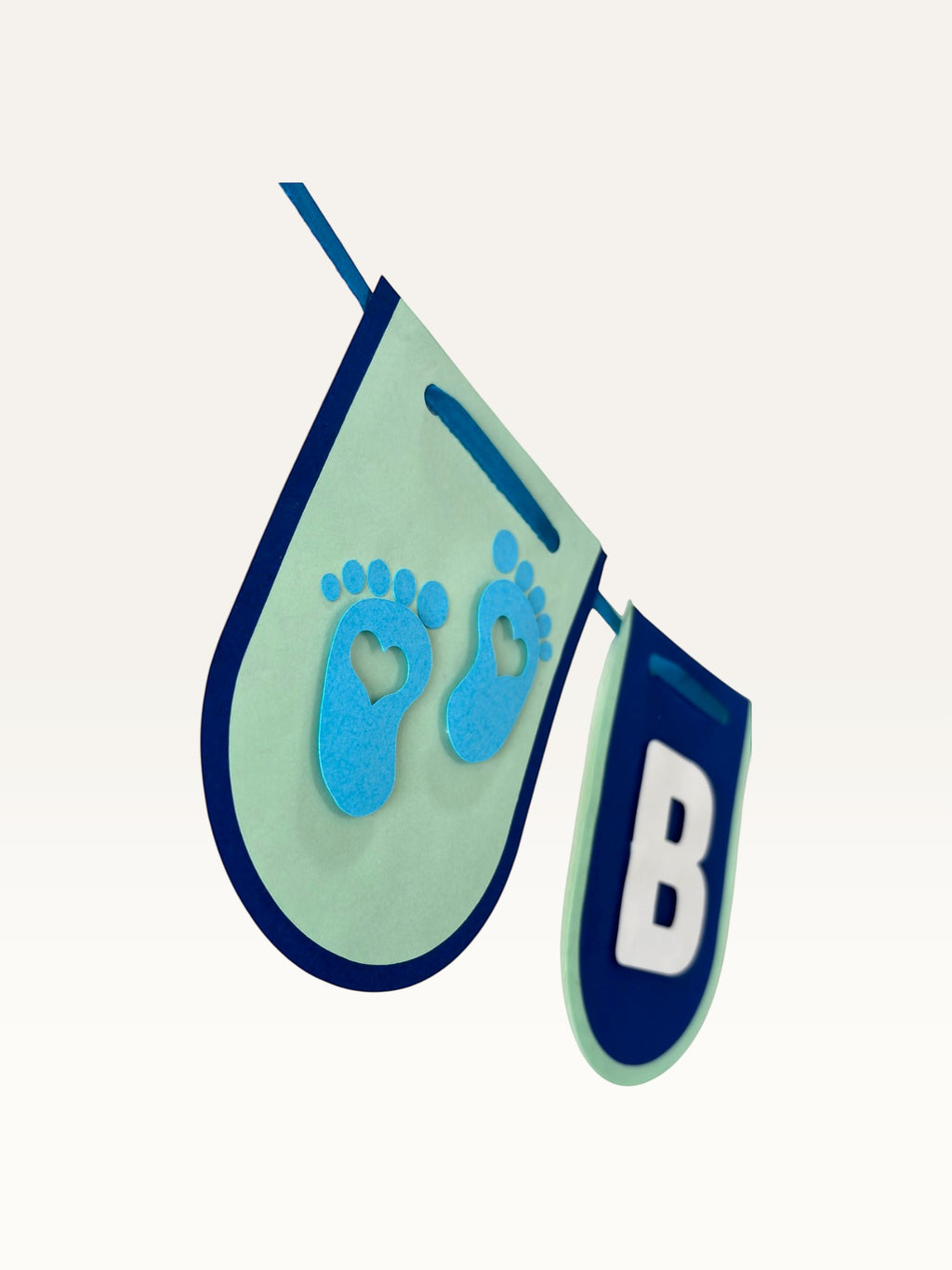 Paper Party Studio navy and sage cardstock baby boy banner with baby feet cut-out and white letter B pennant