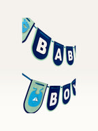 Paper Party Studio navy and sage cardstock Baby Boy banner with white lettering and cute baby-themed cut-outs.