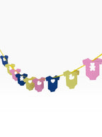 Paper Party Studio pastel baby onesie garland with teddy, heart, and duck cut-outs on yellow ribbon.