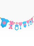 Paper Party Studio pink and blue baby shower garland with teddy bears, onesies, rattles, and baby bottles on a gold cord.