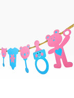 Paper Party Studio pink and blue baby shower garland with teddy bears, rattles, onesies, and baby bottles on gold cord.