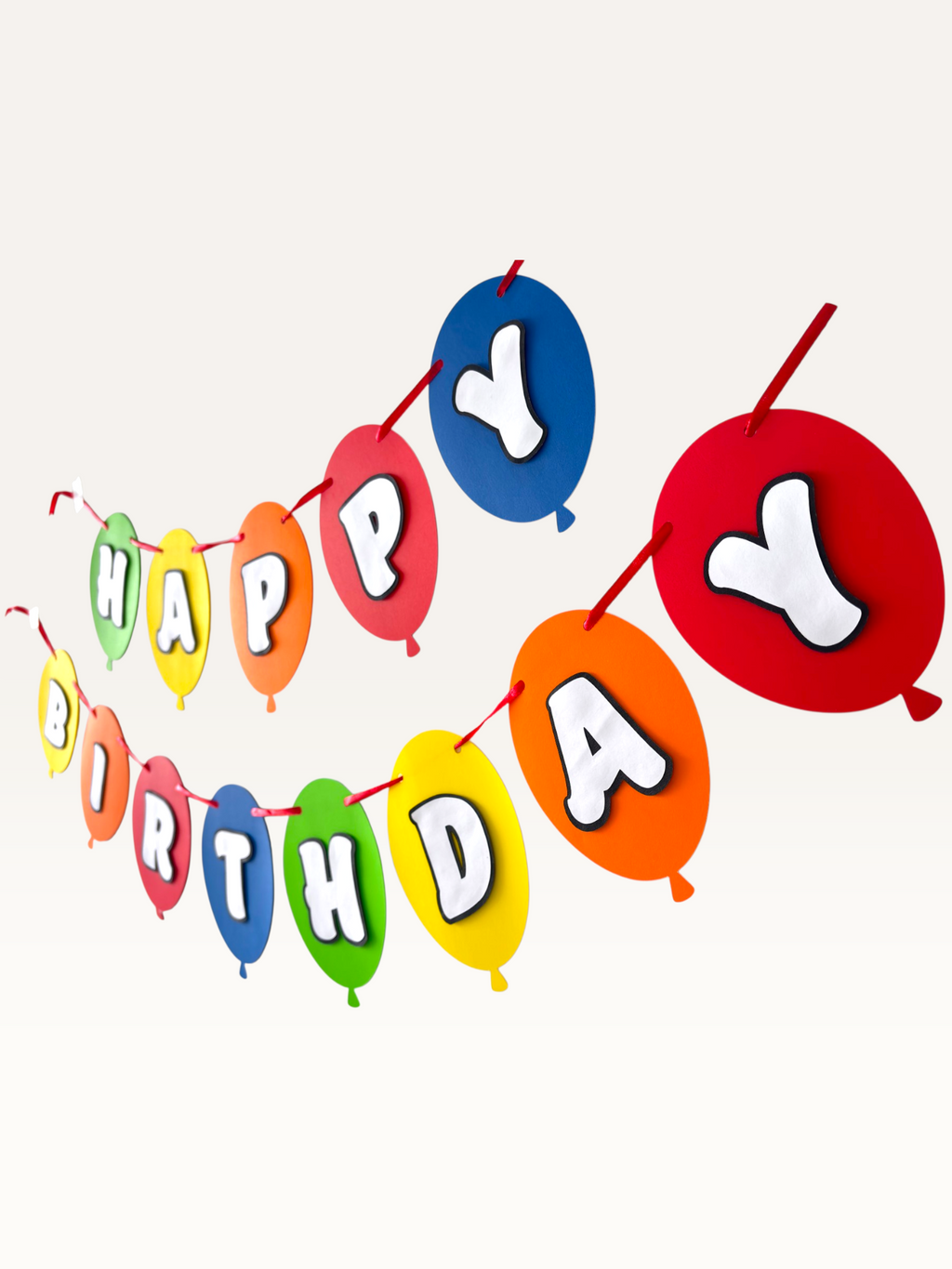 Paper Party Studio multicoloured balloon birthday banner with layered white letters on red, yellow, blue, and green.