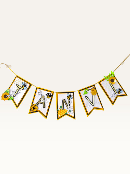 Paper Party Studio personalised bee and honeycomb birthday name banner with gold foil letters on layered flags