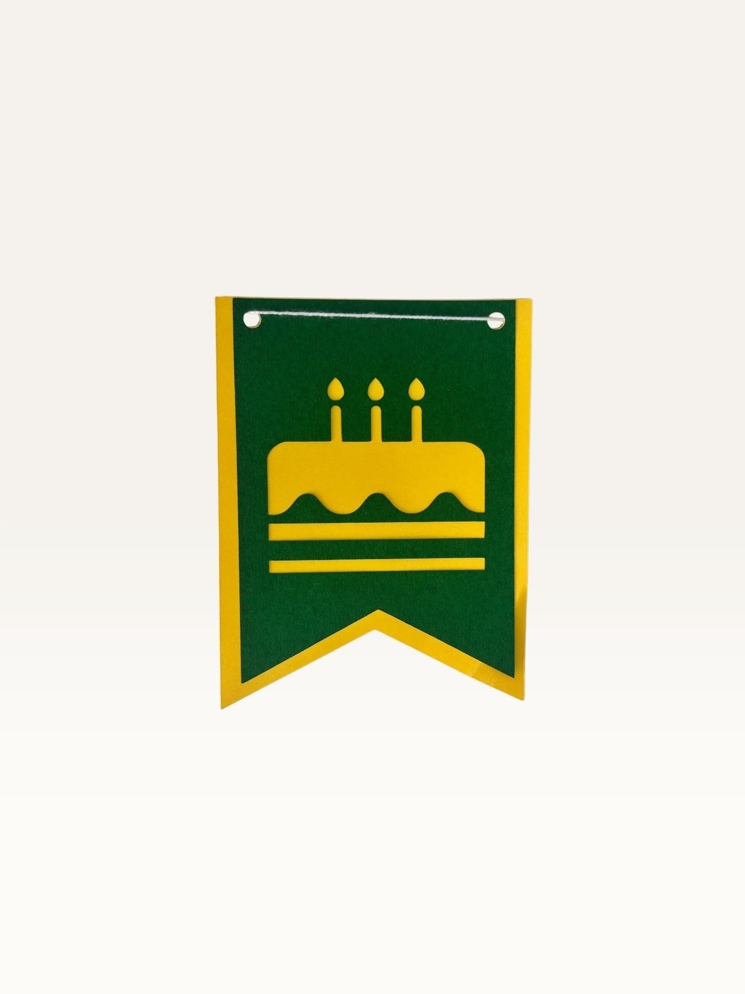 Paper Party Studio swallowtail birthday bunting flag in green cardstock with a yellow cake icon cutout.