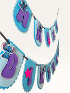 Paper Party Studio blue scalloped Happy Birthday banner with purple letters, alien characters, and pink star accents.