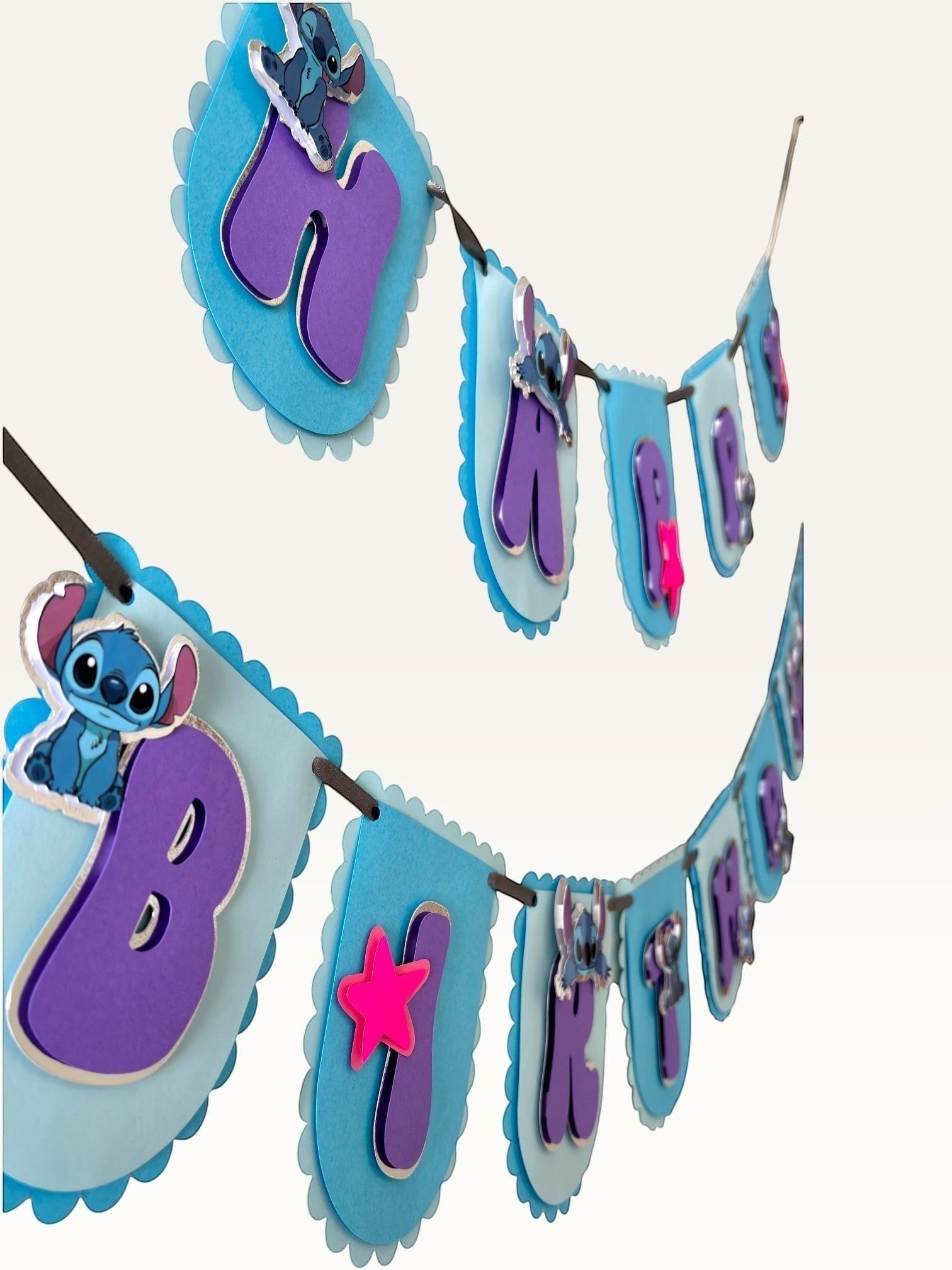 Paper Party Studio blue scalloped Happy Birthday banner with purple letters, alien characters, and pink star accents.