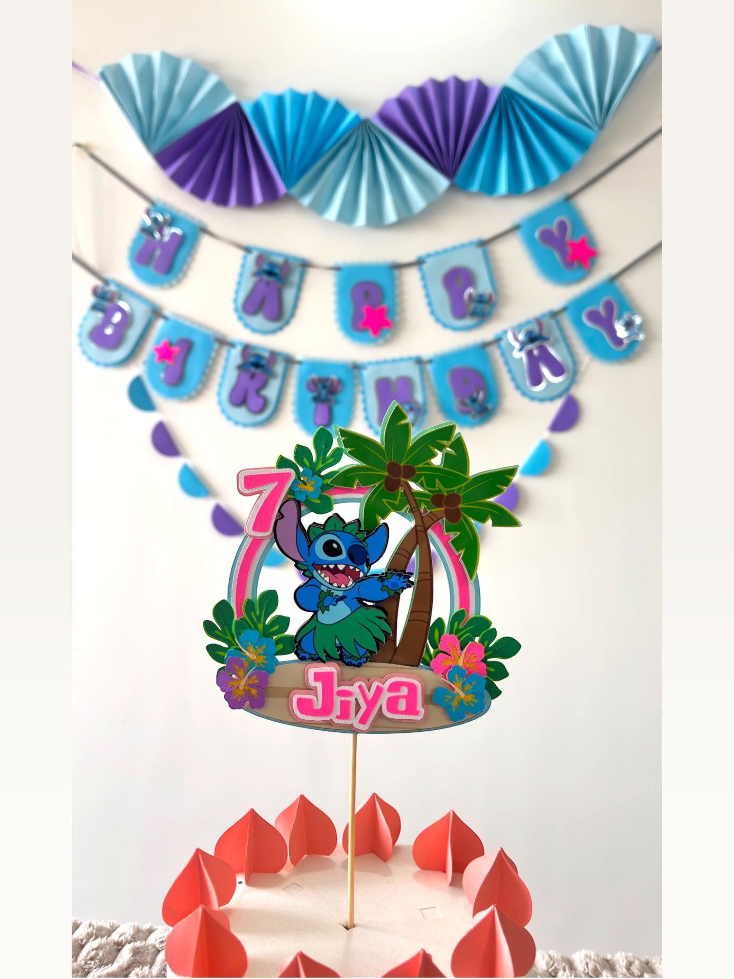 Paper Party Studio tropical luau blue alien birthday cake topper personalised with name and age in front of party decor