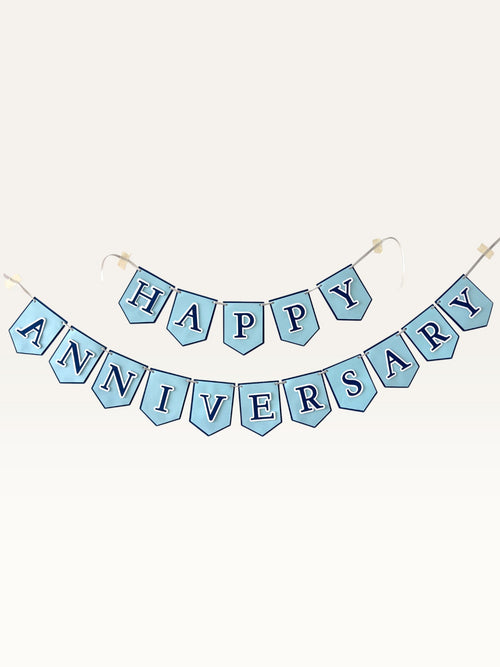 Paper Party Studio Happy Anniversary banner with powder blue flags, navy serif letters, and white outlines.