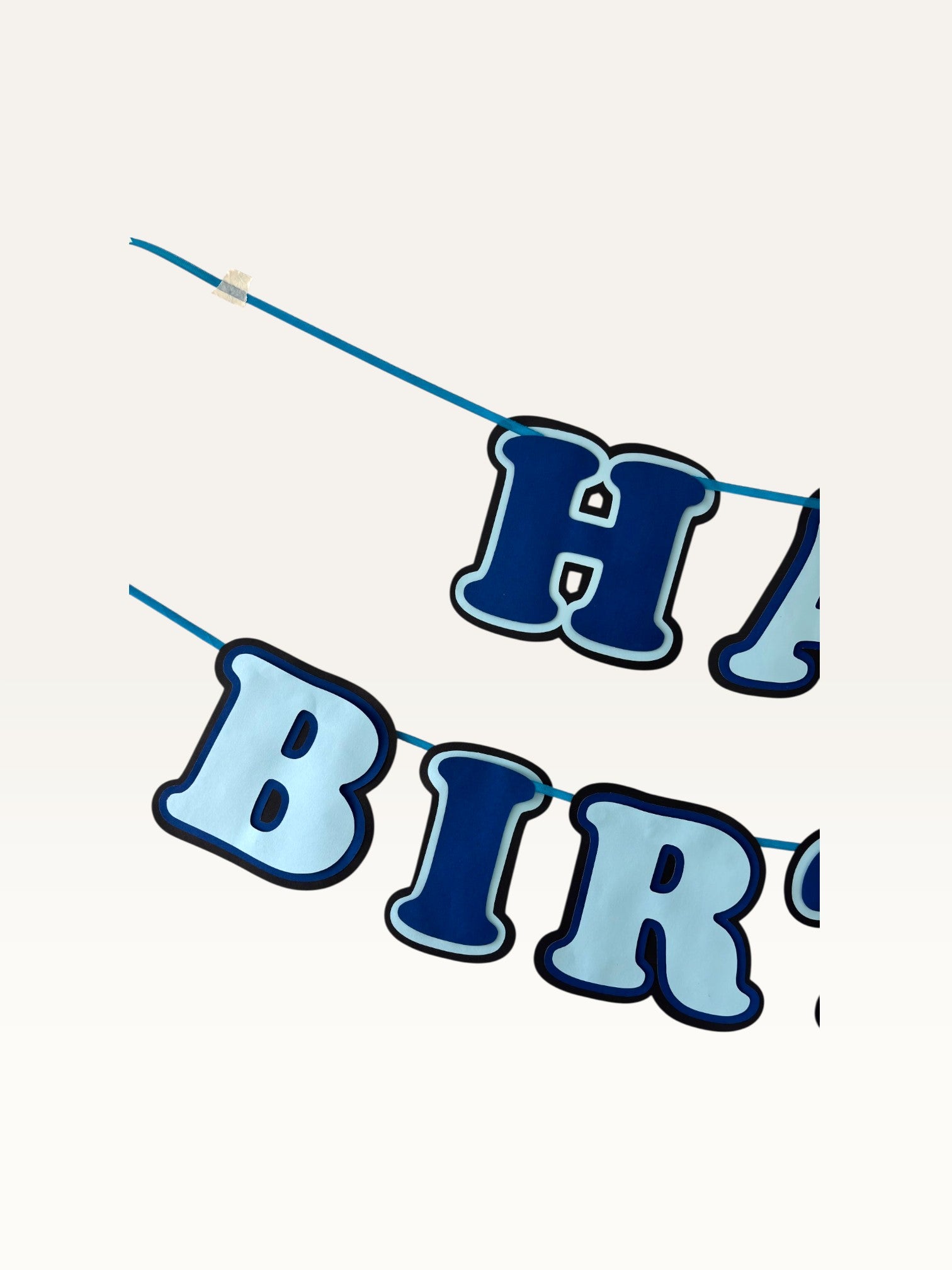Paper Party Studio blue layered paper Happy Birthday banner with dimensional cut-out letters on a hanging cord