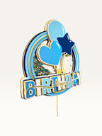 Paper Party Studio blue and gold Happy Birthday shaker cake topper with glitter, sequins, heart, and star details.