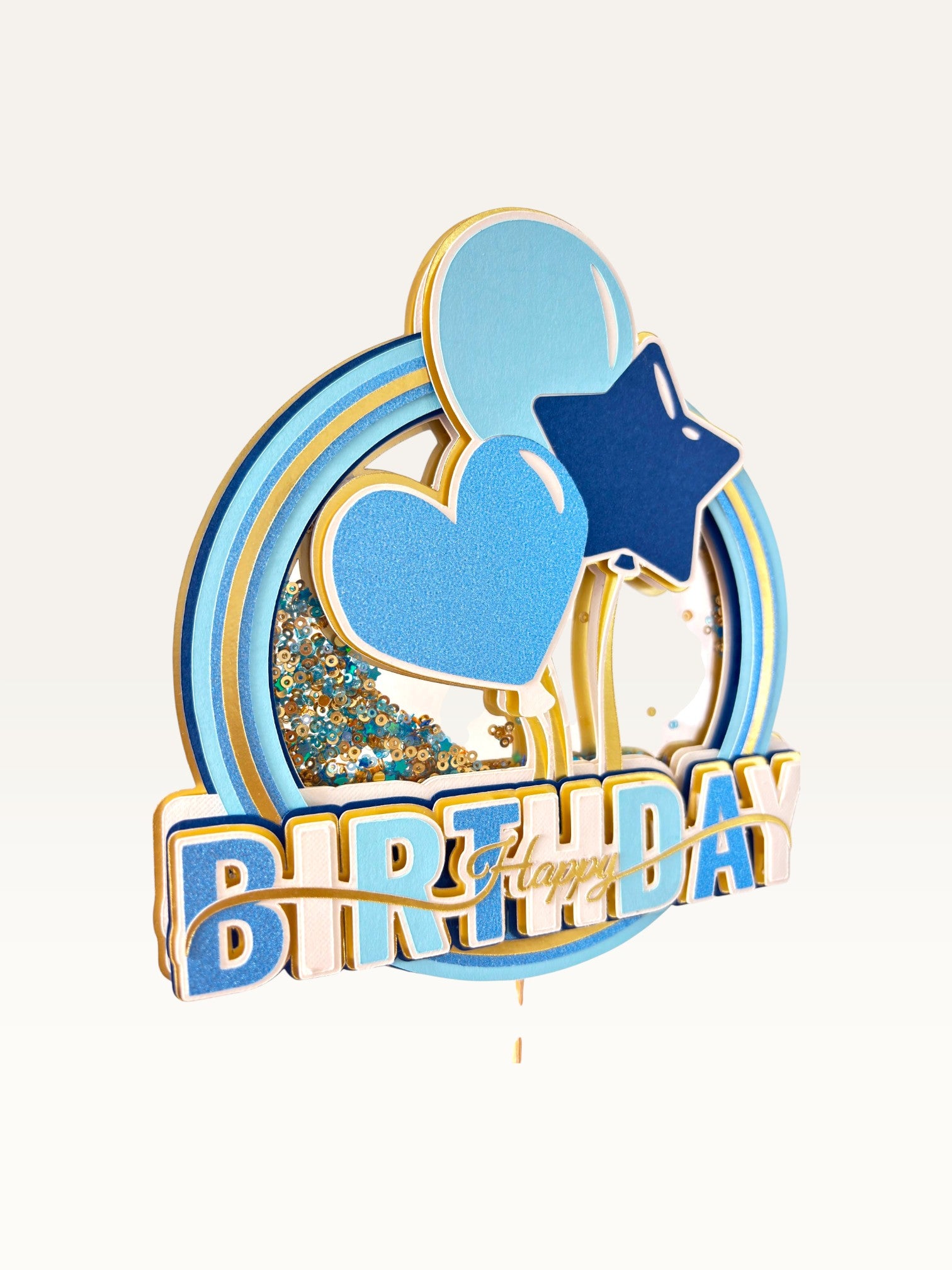 Paper Party Studio blue and gold Happy Birthday shaker cake topper with glitter, sequins, heart, and star accents.