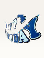 Paper Party Studio blue layered paper Happy Birthday banner with navy and sky blue cut-out letters on a hanging cord.