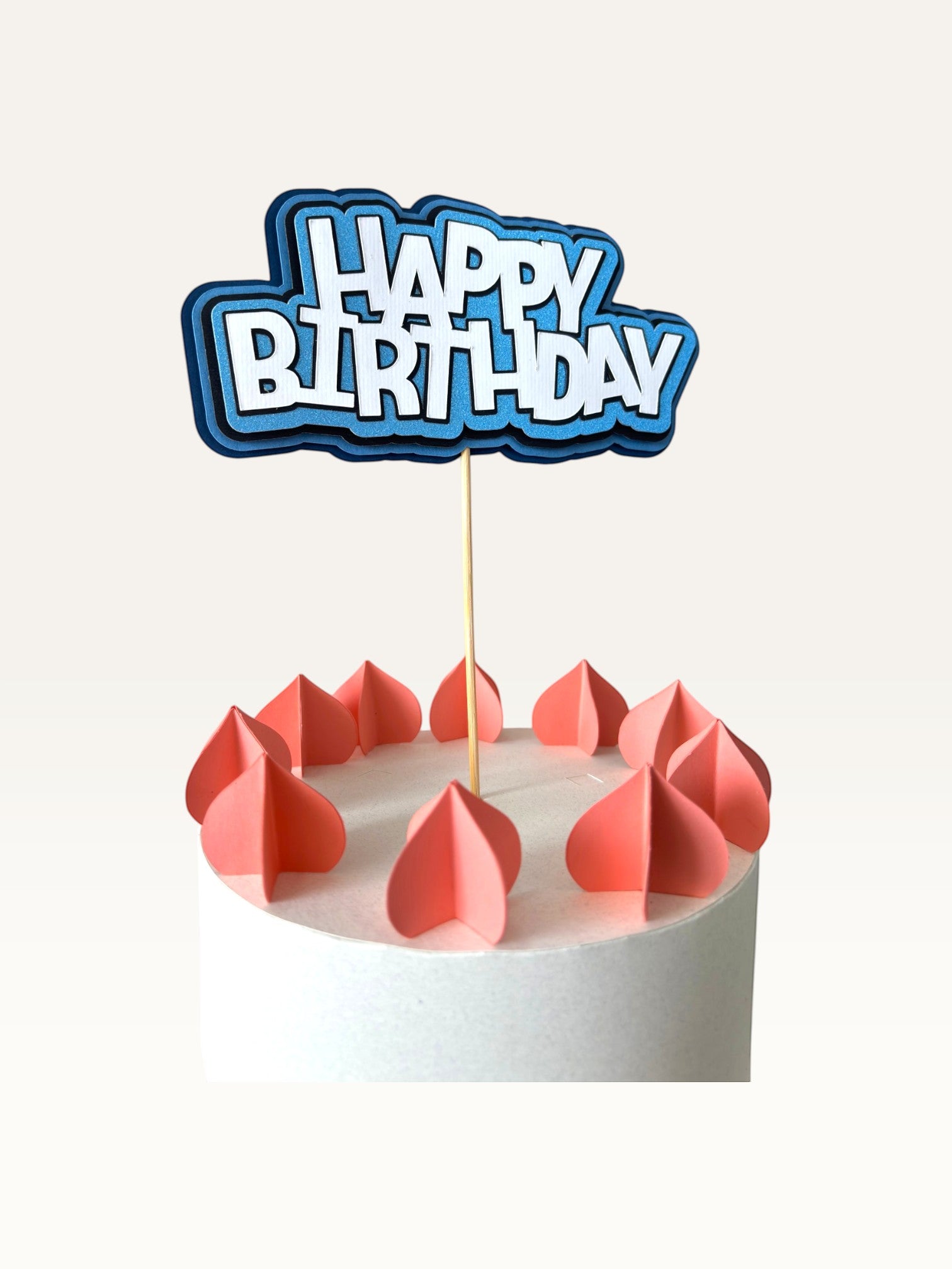 Paper Party Studio blue layered Happy Birthday cake topper with white block letters on a wooden pick