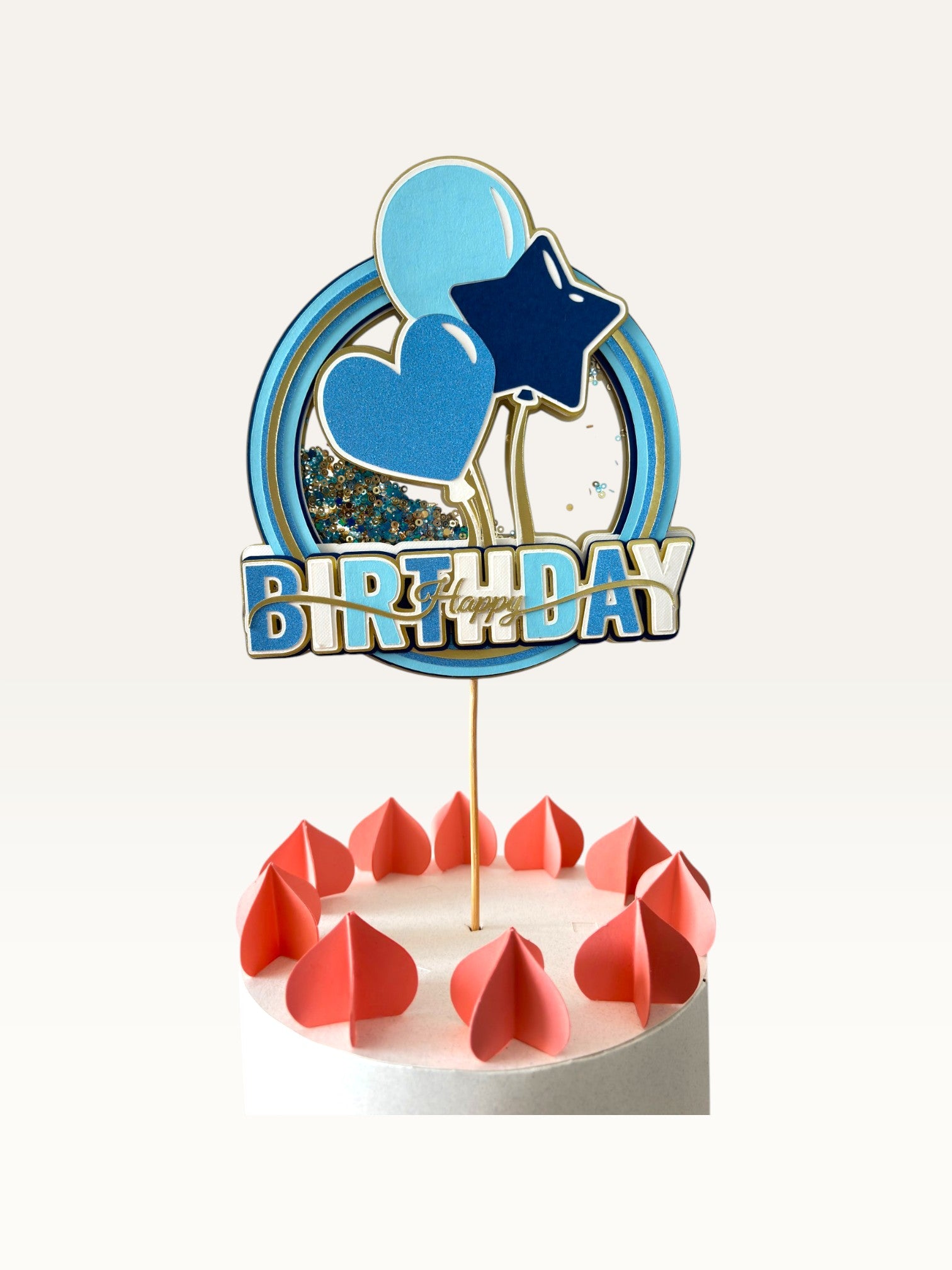 Paper Party Studio blue Happy Birthday cake topper with a glitter and sequin shaker center, balloons, and gold accents.