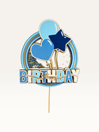 Paper Party Studio blue and gold Happy Birthday shaker cake topper with glitter, sequins, heart, and balloon details.