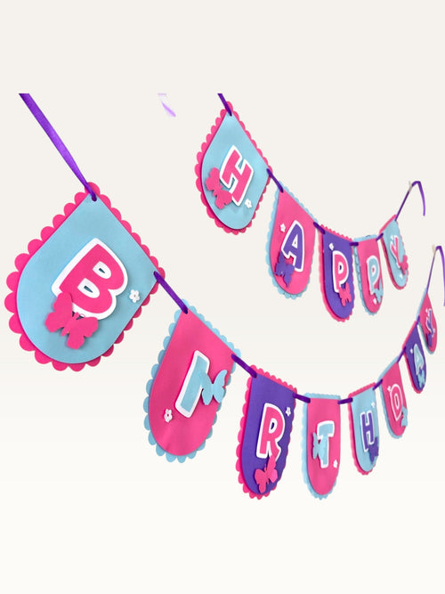 Paper Party Studio Happy Birthday banner with scalloped pink, purple, and blue flags featuring butterfly and daisy art.