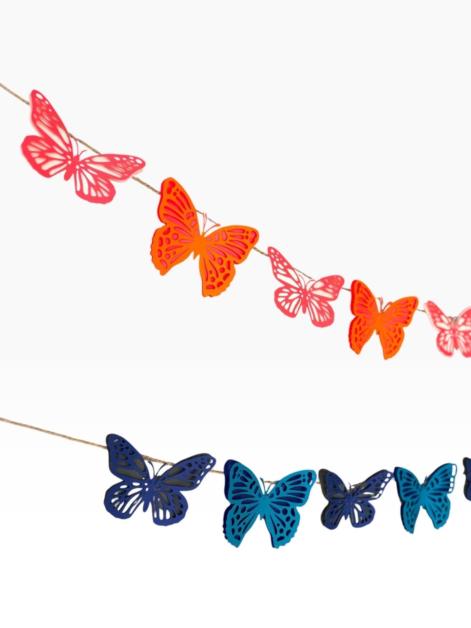 Paper Party Studio butterfly garland in coral, orange, navy, and teal tones. Cardstock butterflies with intricate wings strung on twine.