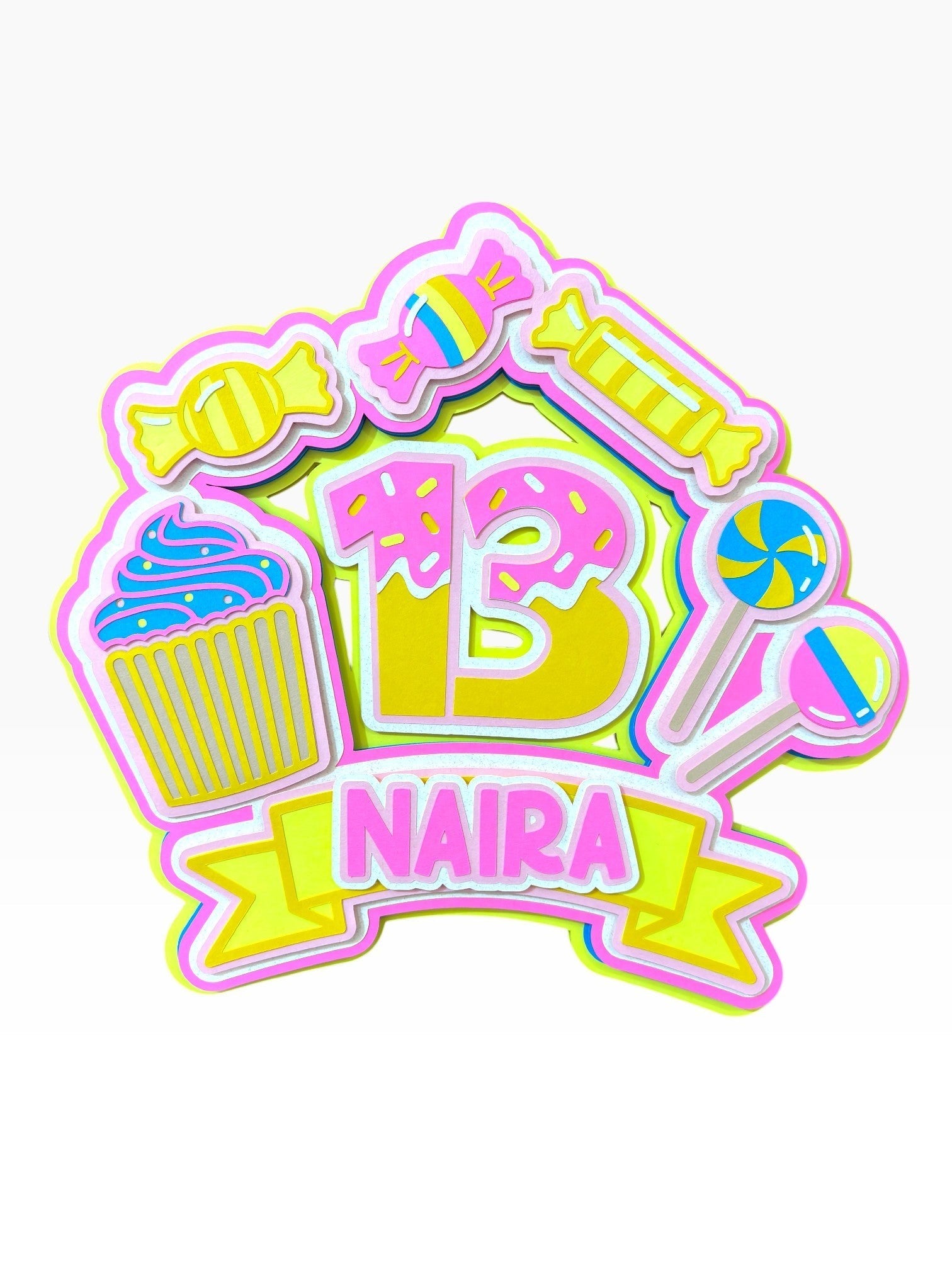 Paper Party Studio personalised candy theme cake topper with '13 NAIRA' text, featuring cupcakes, lollipops, donuts, and sweets in pink, yellow, and blue.