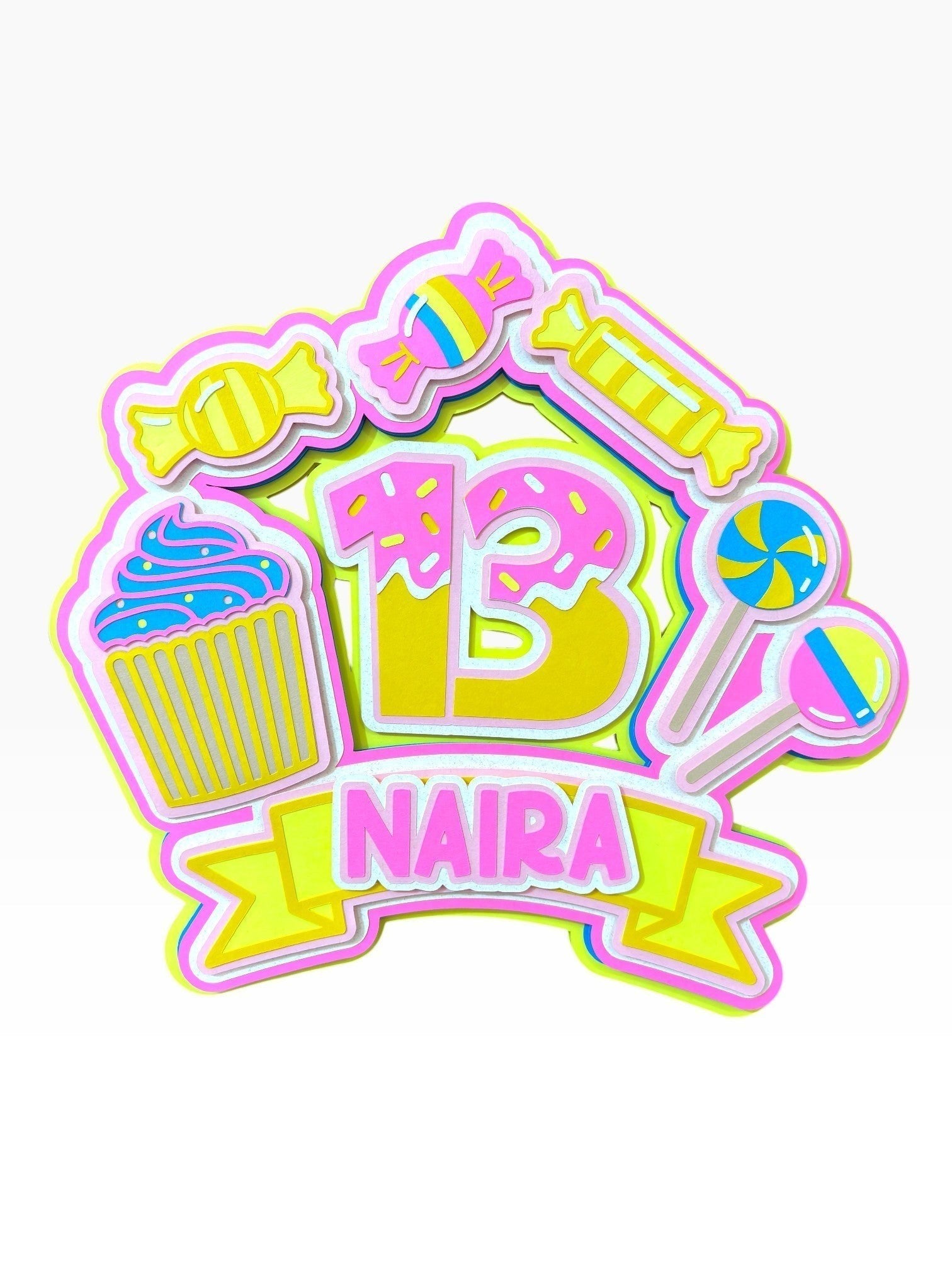 Paper Party Studio personalised candy theme cake topper with '13 NAIRA' text, featuring cupcakes, lollipops, donuts, and sweets in pink, yellow, and blue.