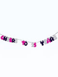 Paper Party Studio 'Cheers to 25 Years' bubble letter garland in pink, black, and white with daisy accents on a silver cord.