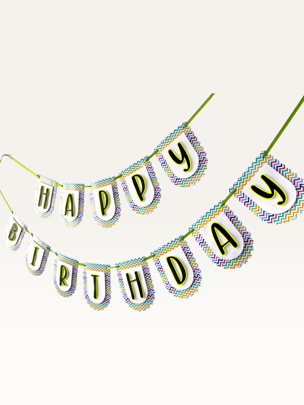 Paper Party Studio Happy Birthday banner with multicolour chevron scalloped paper flags and bold black letters.