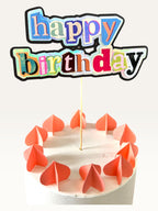 Paper Party Studio maximalist happy birthday cake topper with holographic magazine-style collage letters on a cake.