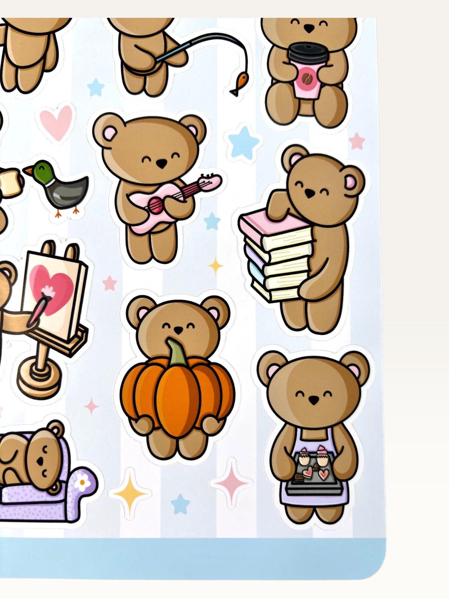 Paper Party Studio glossy sticker sheet featuring cute brown bears with pumpkins, guitars, and books on a blue background