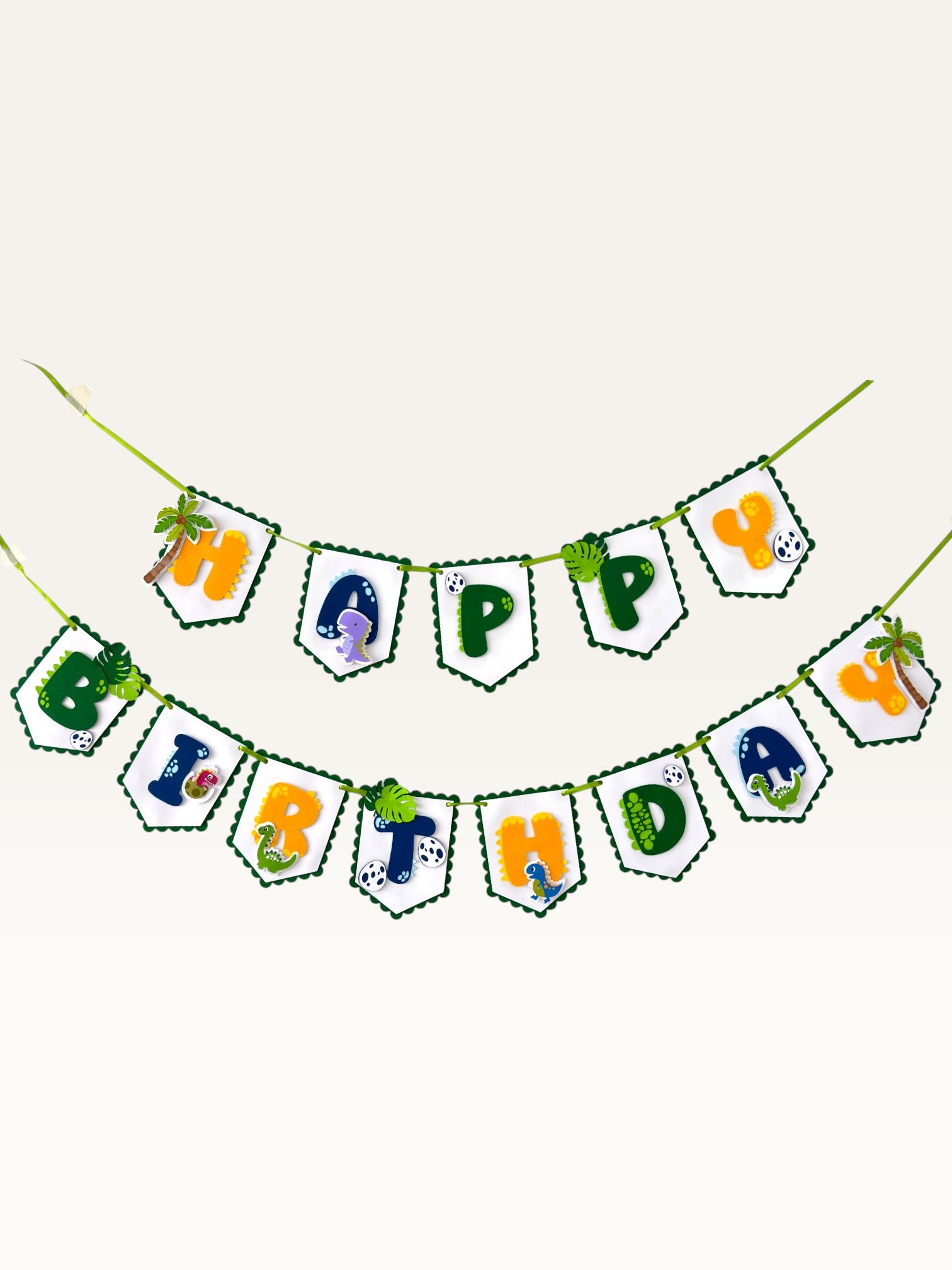Paper Party Studio dinosaur Happy Birthday banner with scalloped flags, jungle leaves, and colourful dino decorations.