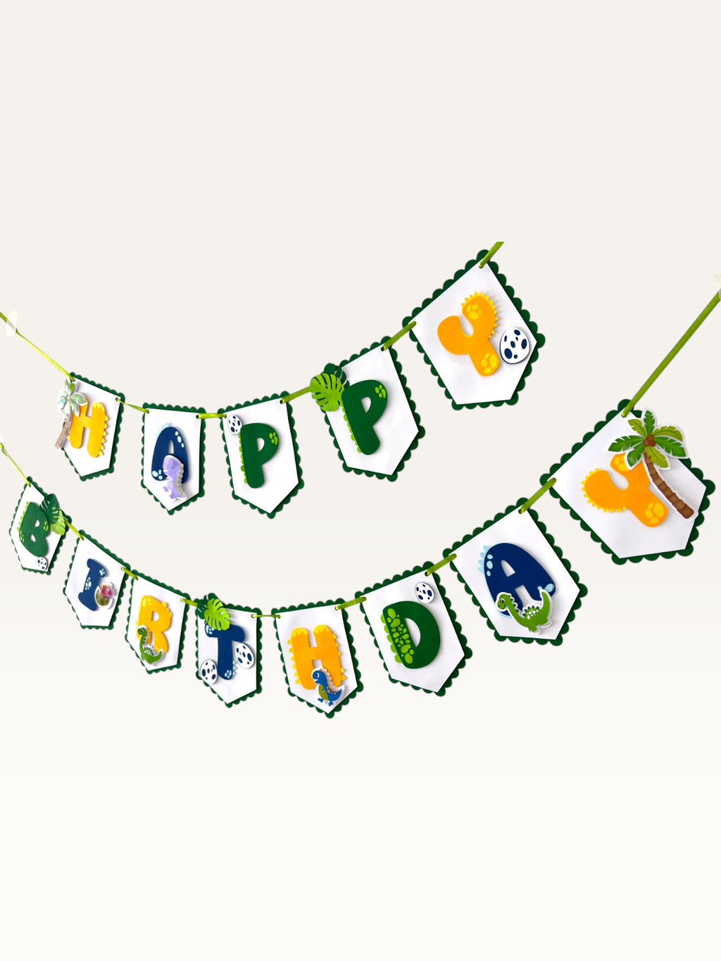 Paper Party Studio dinosaur Happy Birthday banner with scalloped white flags, jungle motifs, and colorful letters.
