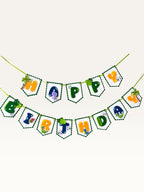 Paper Party Studio dinosaur Happy Birthday banner with scalloped white flags, green borders, and jungle dino motifs.