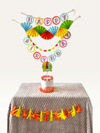 Paper Party Studio personalised dinosaur birthday decoration set with colourful paper fans, banners, and cake topper.