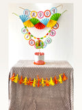 Paper Party Studio dinosaur birthday party decoration set with personalised cake topper, banners, and tassel garland.