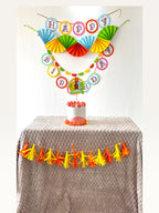 Paper Party Studio dinosaur birthday party decoration set with personalised cake topper, banners, and tassel garland.