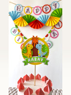 Paper Party Studio personalised dinosaur cake topper with a Happy Birthday banner and colourful paper party decorations.