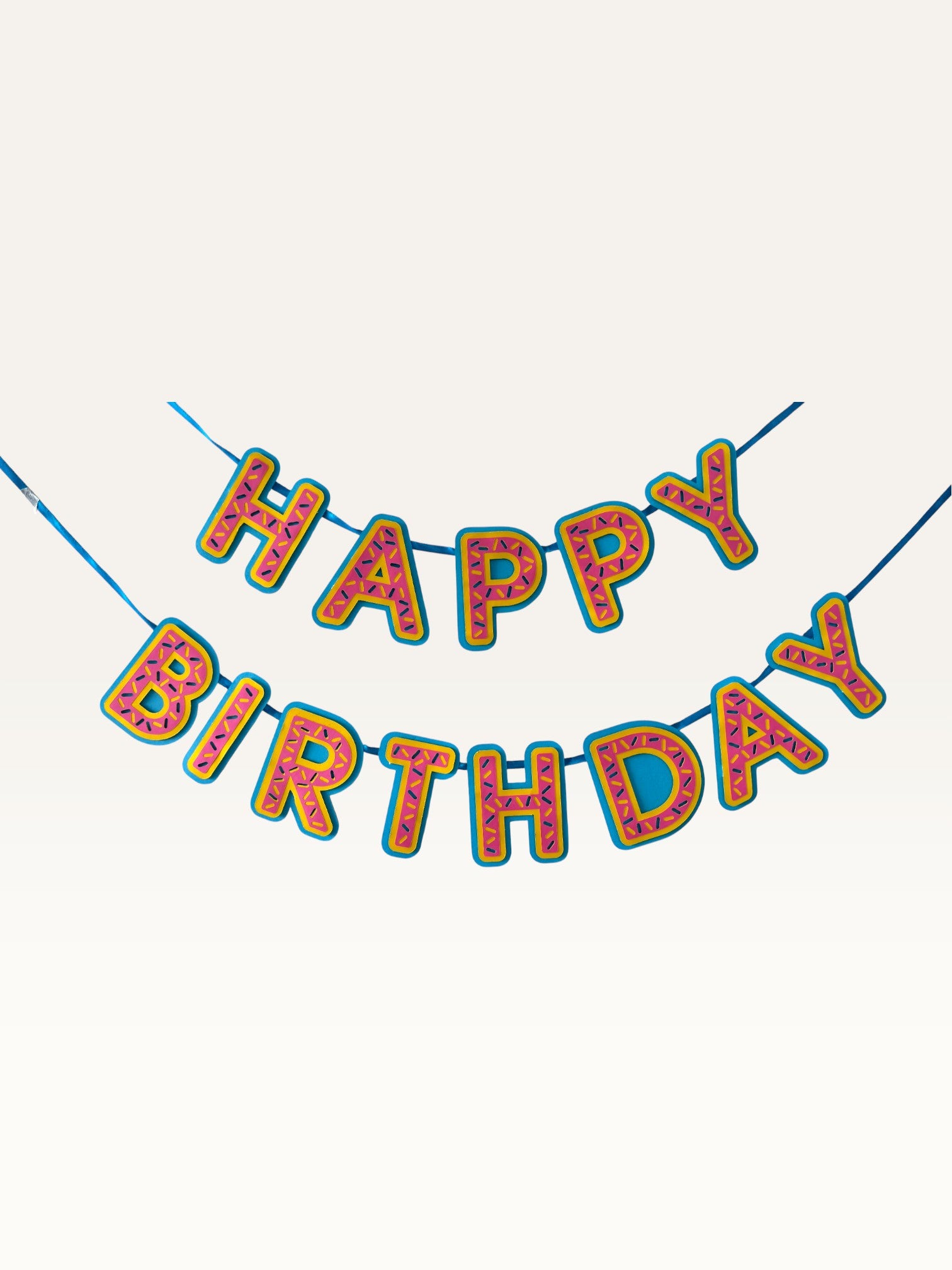 Paper Party Studio pink donut-glaze Happy Birthday paper bunting banner with candy sprinkle details on blue string.