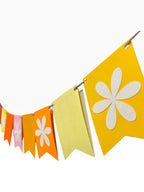 Paper Party Studio bright multi-color fishtail bunting with white flower cut-outs on alternating flags.
