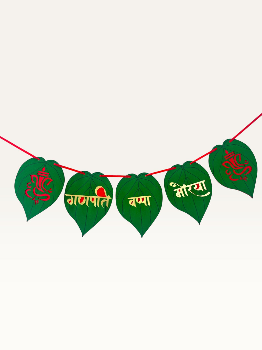 Paper Party Studio Ganpati Bappa Morya banner with green paan-leaf paper flags, gold and red lettering, and Ganesha motifs.