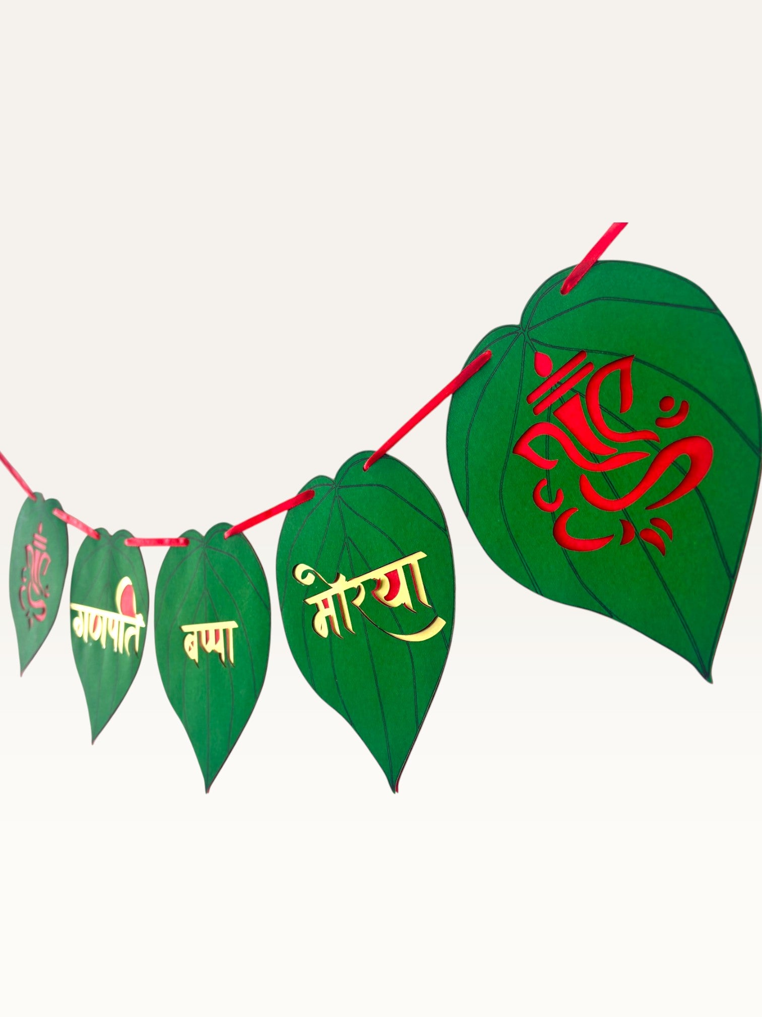 Paper Party Studio Ganpati Bappa Morya banner featuring green paan-leaf paper flags with gold and red Ganesha motifs.