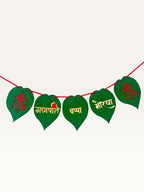 Paper Party Studio Ganpati Bappa Morya banner with green paan-leaf paper flags, gold and red lettering, and Ganesha.