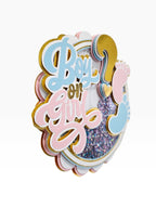 Paper Party Studio Boy or Girl glitter shaker cake topper with pink and blue baby feet and gold foil details.