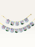 Paper Party Studio Gingham Garden birthday banner with blue checkered flags, pink letters, and floral decorations.