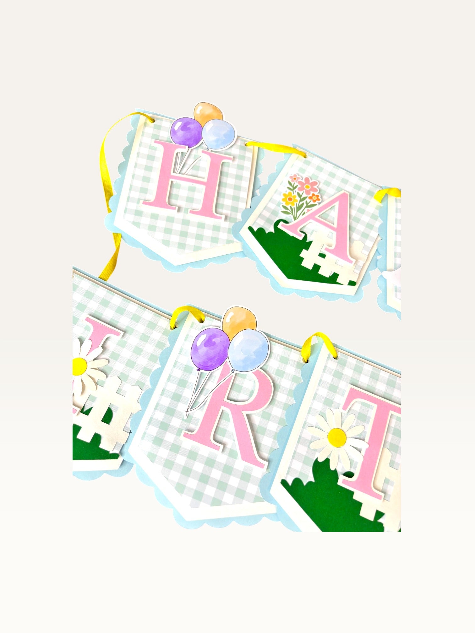 Paper Party Studio Gingham Garden birthday banner with pastel blue check flags, pink letters, balloons, and daisies.