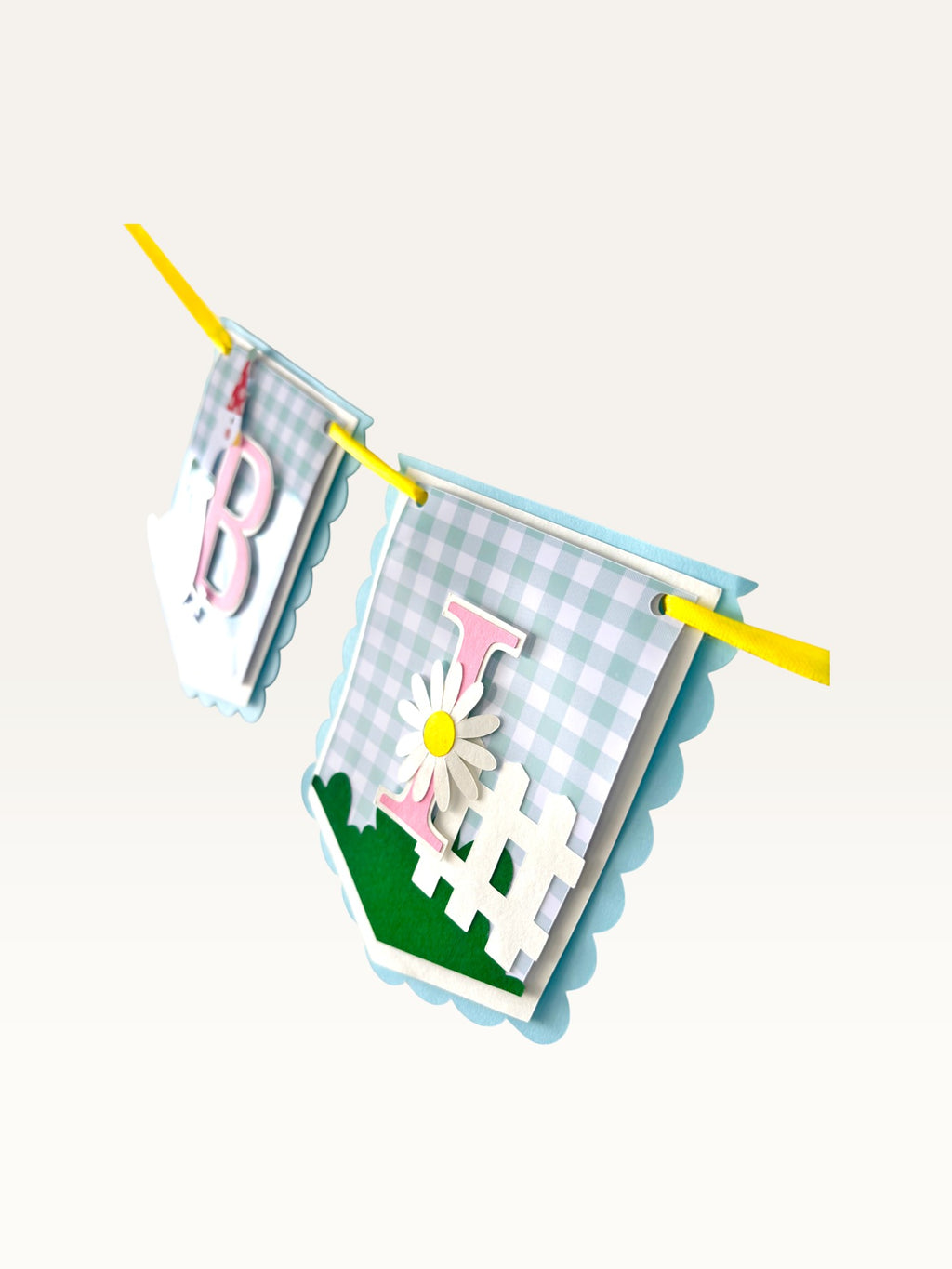 Paper Party Studio Gingham Garden birthday banner featuring blue gingham flags with pink letters and daisy accents.